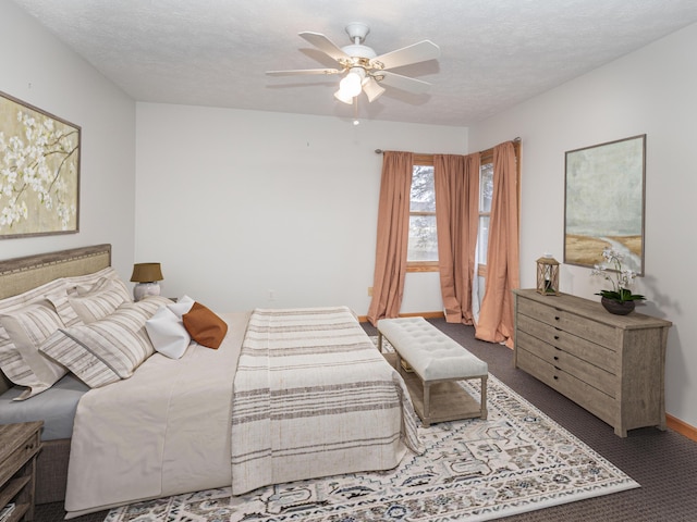 bedroom featuring a textured ceiling, carpet, a ceiling fan, and baseboards