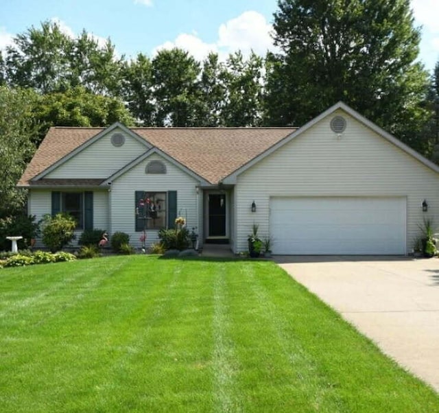 ranch-style house featuring a garage, concrete driveway, and a front yard