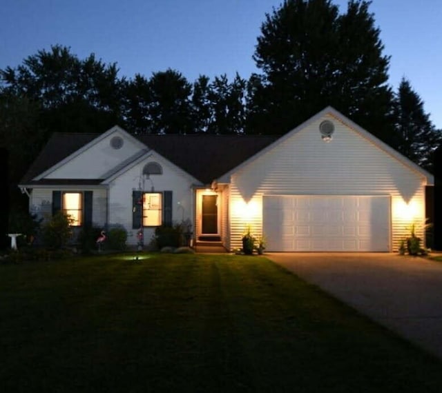 ranch-style house with driveway, a garage, and a front yard