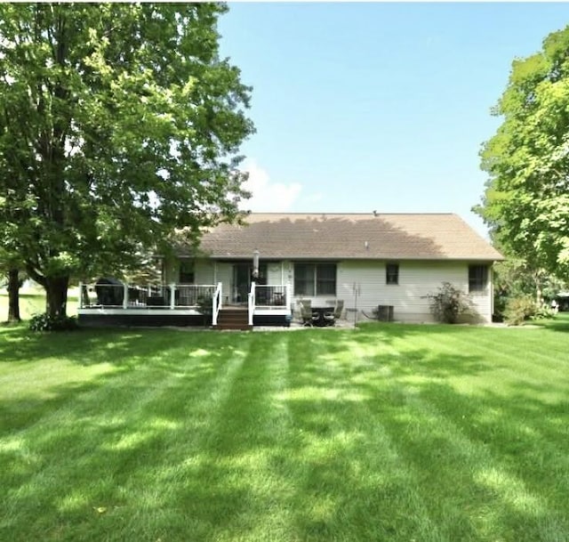 back of property featuring a yard, cooling unit, and a wooden deck