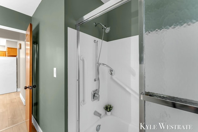 full bath with bathing tub / shower combination and wood finished floors