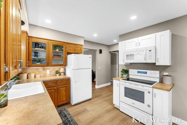 kitchen with white appliances, light countertops, and a sink