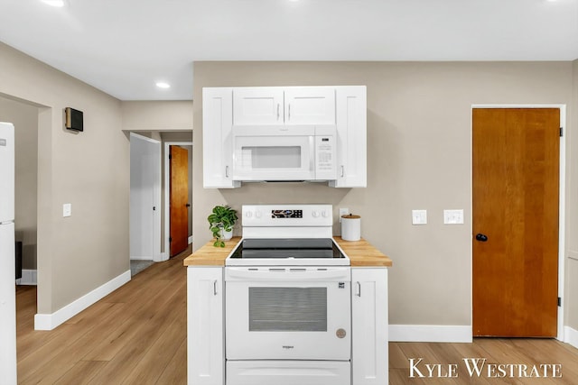 kitchen with white appliances, light wood-type flooring, white cabinetry, and baseboards