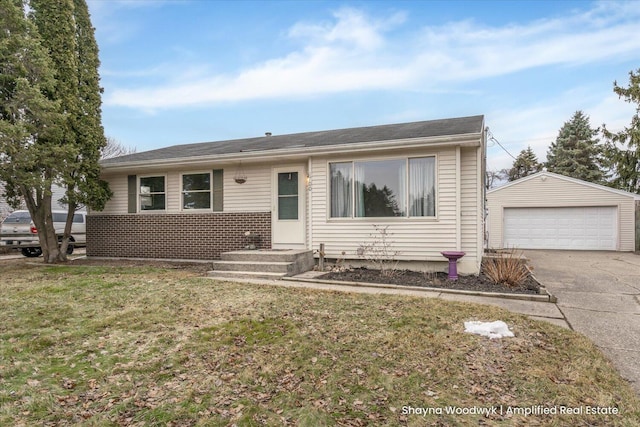 view of front of house featuring an outbuilding, brick siding, a detached garage, and a front lawn