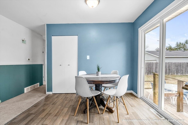 dining room with visible vents, baseboards, and wood finished floors