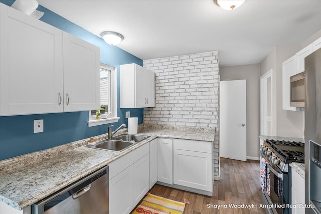 kitchen with white cabinetry, appliances with stainless steel finishes, dark wood finished floors, and a sink