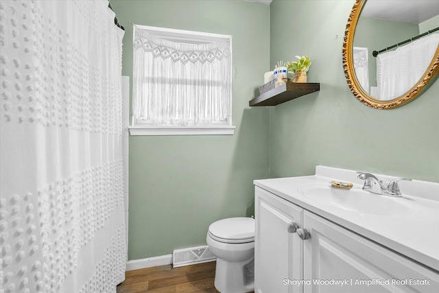 full bath with toilet, wood finished floors, vanity, visible vents, and baseboards