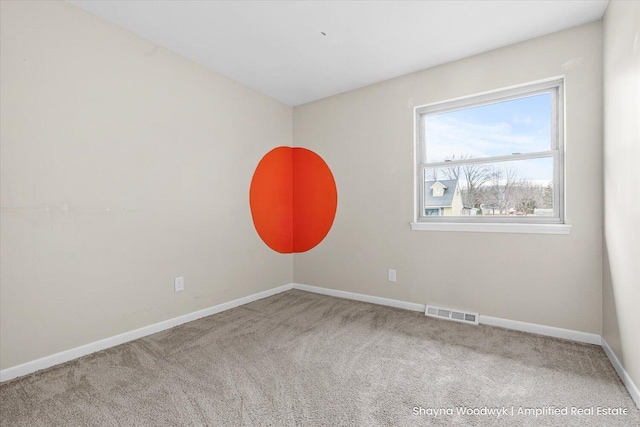 unfurnished room featuring carpet, visible vents, and baseboards