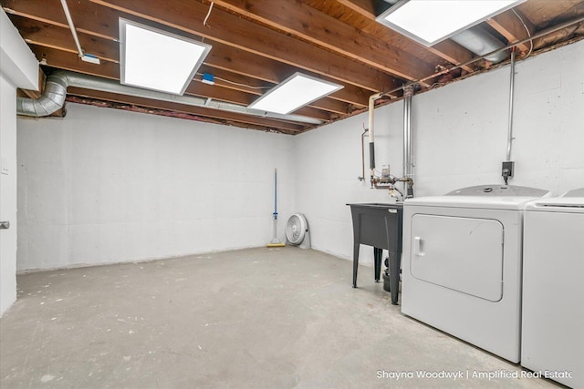 clothes washing area with laundry area, washer and clothes dryer, and a sink