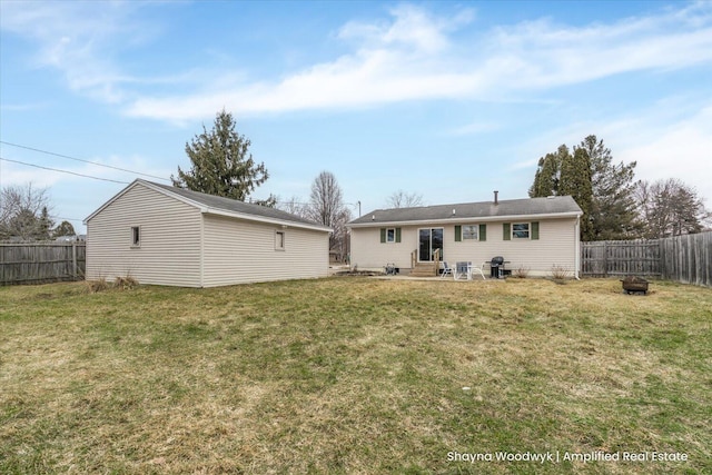 rear view of property with entry steps, a fenced backyard, and a yard