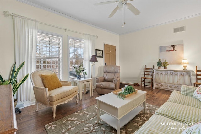 living room featuring visible vents, ornamental molding, ceiling fan, wood finished floors, and baseboards