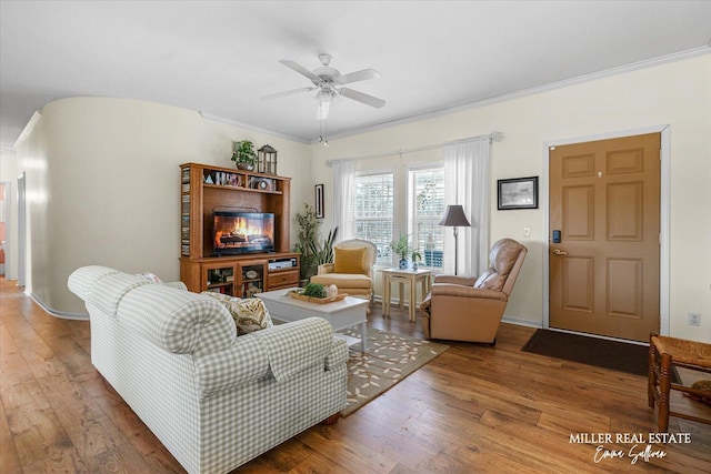 living room with ceiling fan, baseboards, hardwood / wood-style flooring, and crown molding