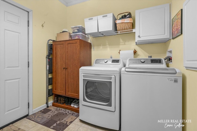 laundry area featuring washing machine and dryer, cabinet space, and crown molding