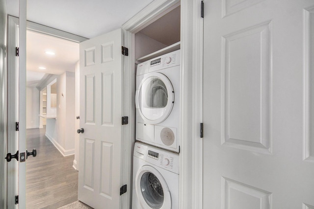 washroom with laundry area, wood finished floors, and stacked washer and clothes dryer