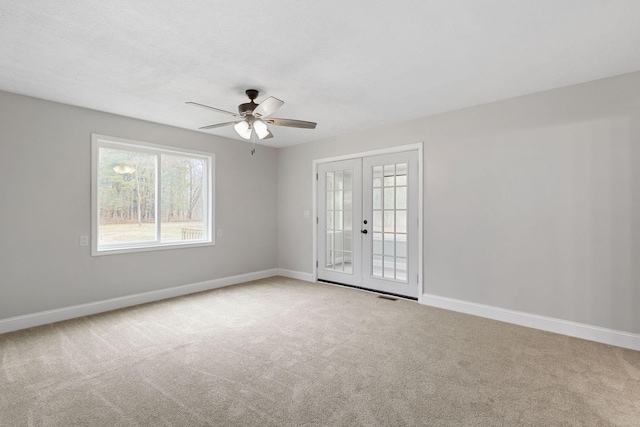 unfurnished room featuring french doors, carpet flooring, ceiling fan, a textured ceiling, and baseboards