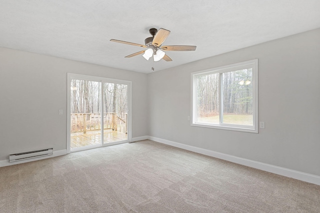 unfurnished room featuring a ceiling fan, carpet, a baseboard heating unit, and baseboards