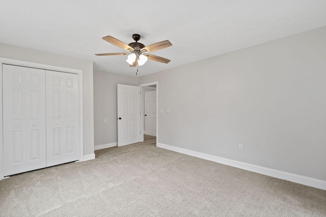 unfurnished bedroom featuring carpet floors, a closet, a ceiling fan, and baseboards