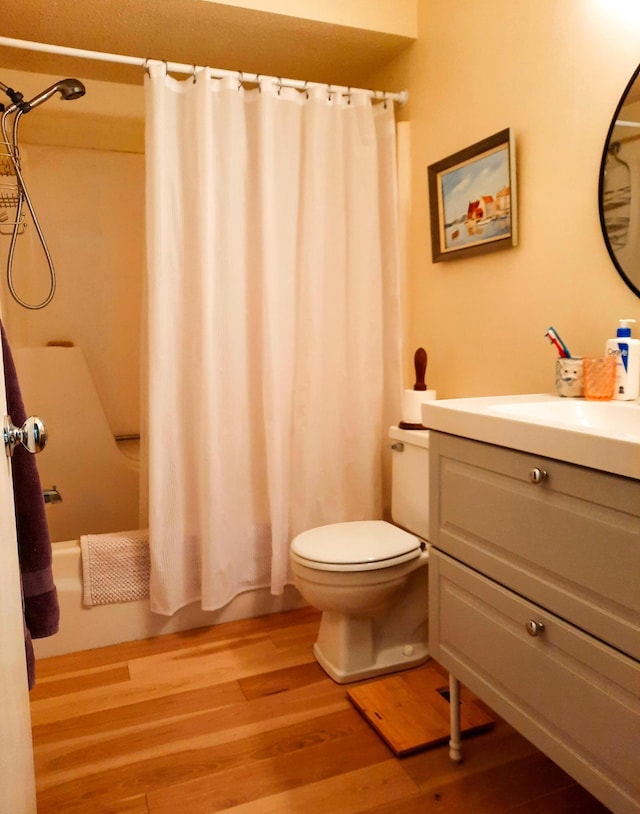 full bathroom featuring vanity, shower / bath combo, wood finished floors, and toilet