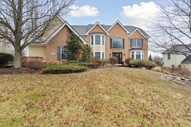 traditional home featuring brick siding and a front lawn