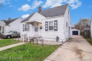 bungalow-style house with an outbuilding and a detached garage