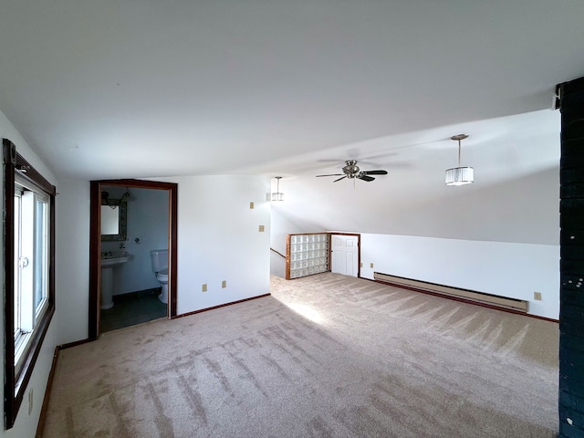 carpeted spare room with vaulted ceiling, a baseboard radiator, and baseboards