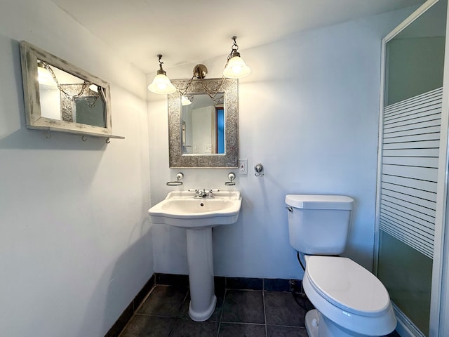 bathroom with baseboards, a sink, toilet, and tile patterned floors