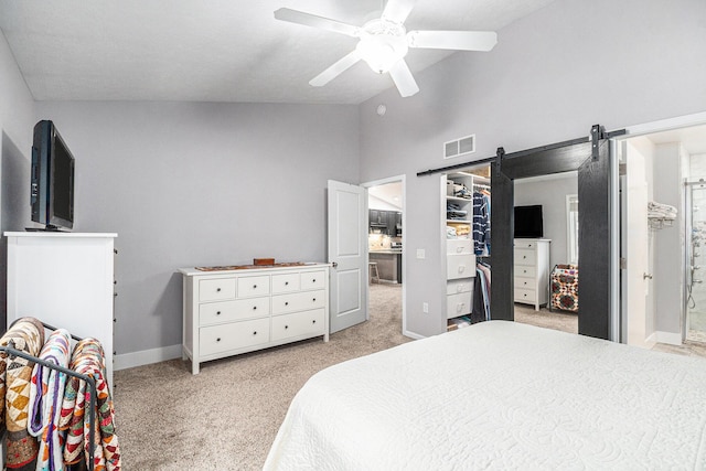 bedroom featuring light colored carpet, visible vents, a barn door, ceiling fan, and vaulted ceiling