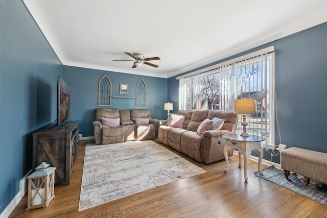 living room featuring baseboards, wood finished floors, and ceiling fan