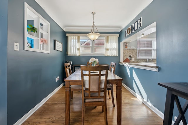 dining area with baseboards and wood finished floors