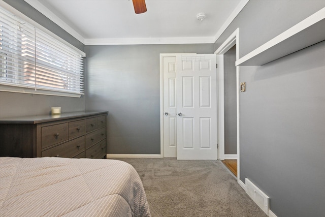 bedroom with visible vents, baseboards, ornamental molding, carpet floors, and a ceiling fan