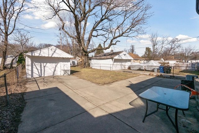 view of patio / terrace with a fenced backyard, a detached garage, and an outdoor structure