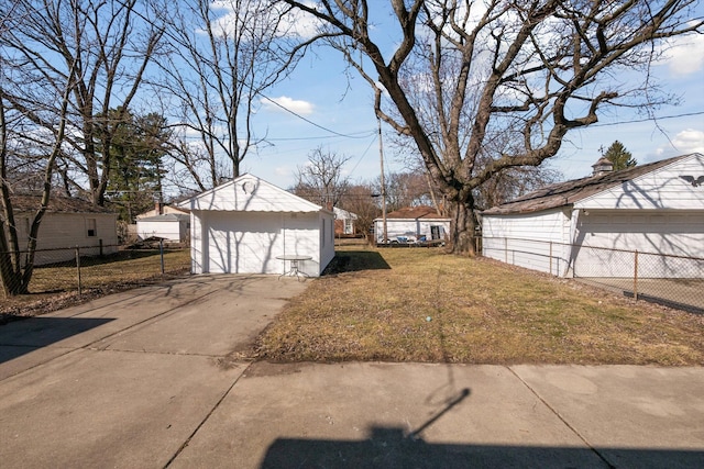 view of yard with a garage, an outbuilding, and fence