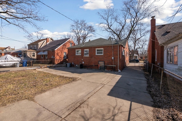 back of property featuring a gate, a residential view, brick siding, and fence