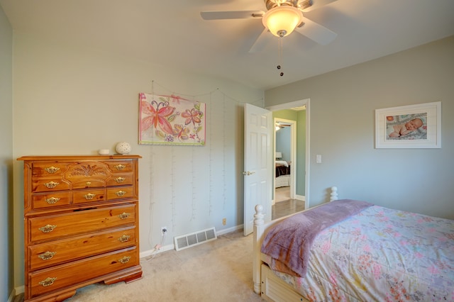 bedroom featuring a ceiling fan, baseboards, visible vents, and light carpet