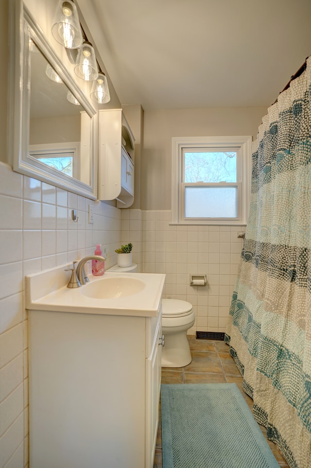 bathroom featuring tile patterned floors, visible vents, toilet, tile walls, and vanity