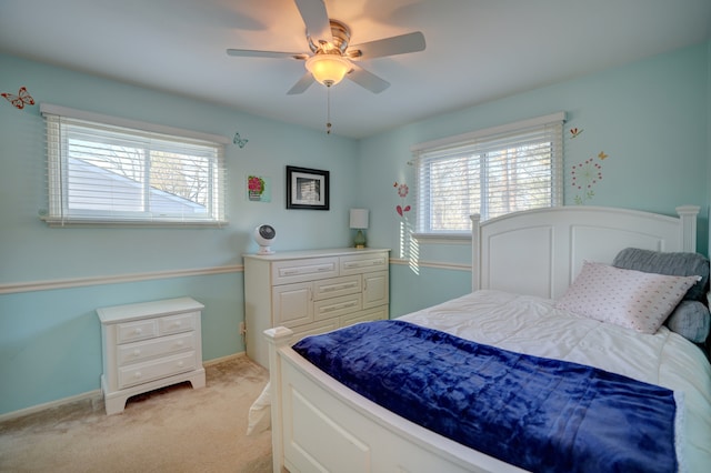 bedroom featuring baseboards, light carpet, and ceiling fan