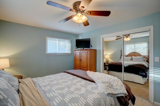 bedroom with light carpet, multiple windows, a closet, and a ceiling fan