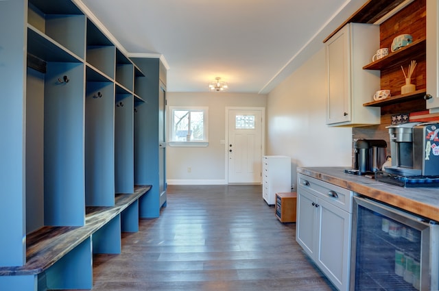 interior space featuring beverage cooler, baseboards, open shelves, dark wood-style flooring, and white cabinetry