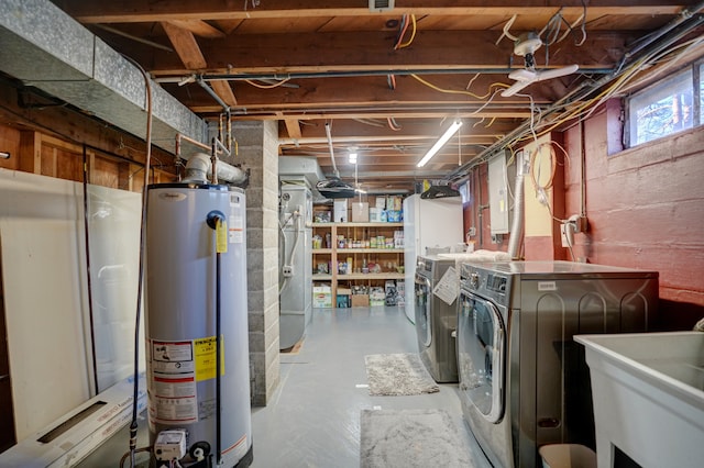 below grade area featuring a sink, washing machine and dryer, and water heater