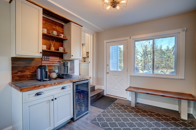 kitchen featuring wood finished floors, open shelves, wine cooler, white cabinetry, and tasteful backsplash