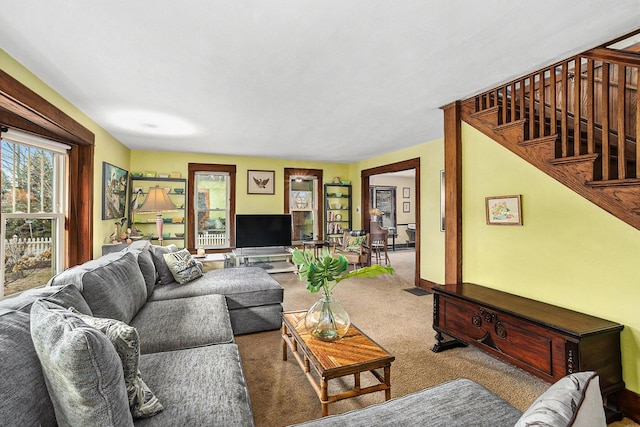 living room with stairway and carpet flooring