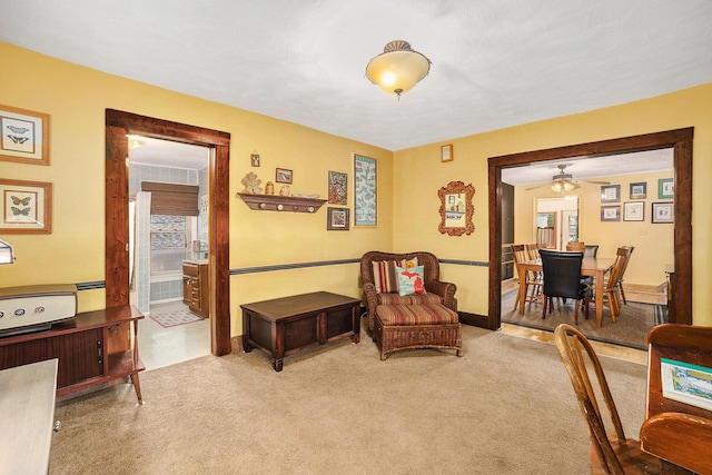 sitting room featuring a ceiling fan, carpet flooring, and baseboard heating