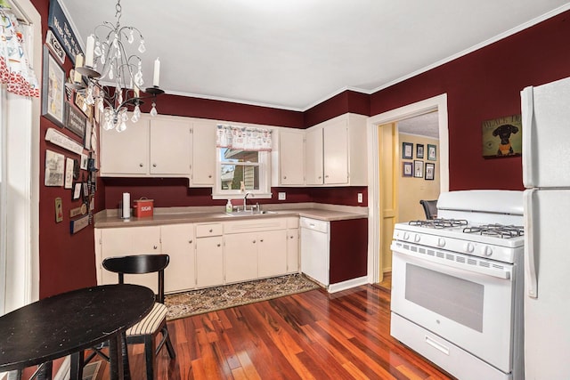 kitchen with dark wood finished floors, a notable chandelier, white cabinetry, a sink, and white appliances