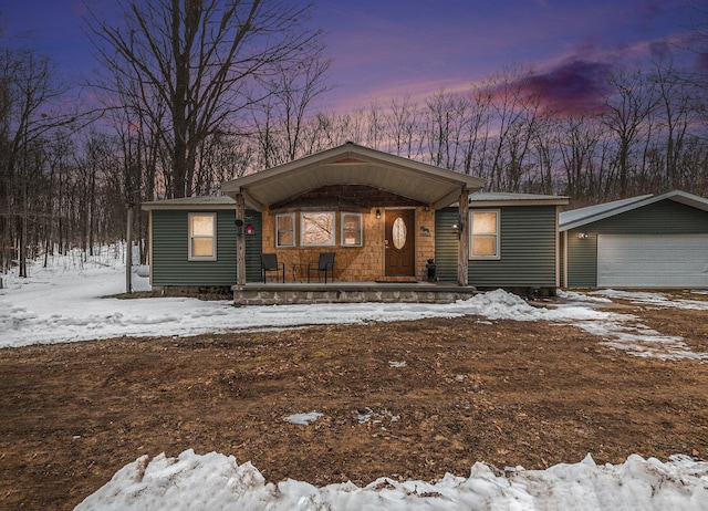 view of front of house with covered porch, an outbuilding, and a garage