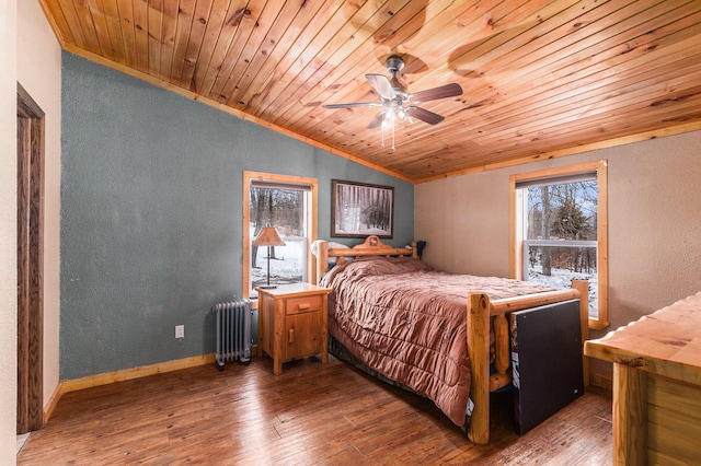 bedroom with radiator, wood-type flooring, vaulted ceiling, and a textured wall