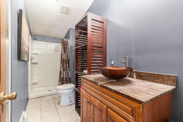 bathroom featuring a shower with curtain, toilet, a textured ceiling, vanity, and tile patterned flooring