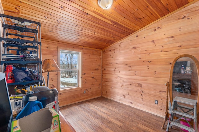 interior space with lofted ceiling, wooden ceiling, wood finished floors, and wooden walls