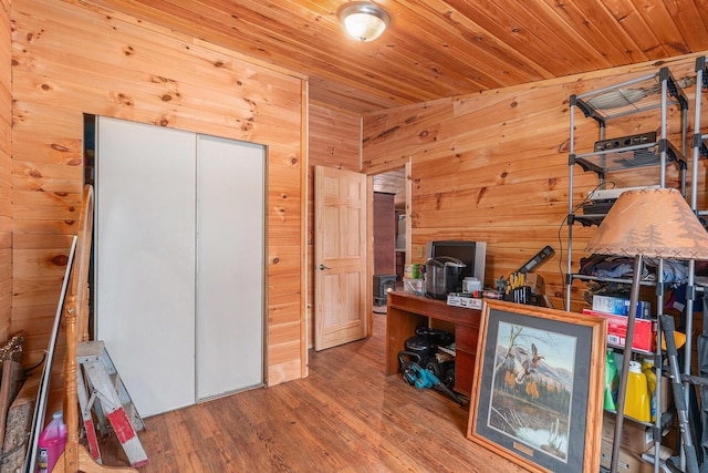 unfurnished office featuring wood ceiling, wood walls, and wood finished floors