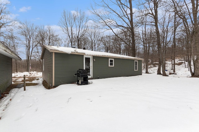 view of snow covered rear of property