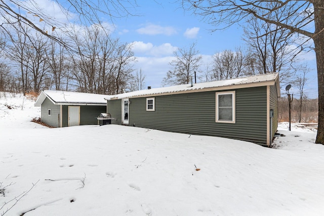 view of snow covered back of property